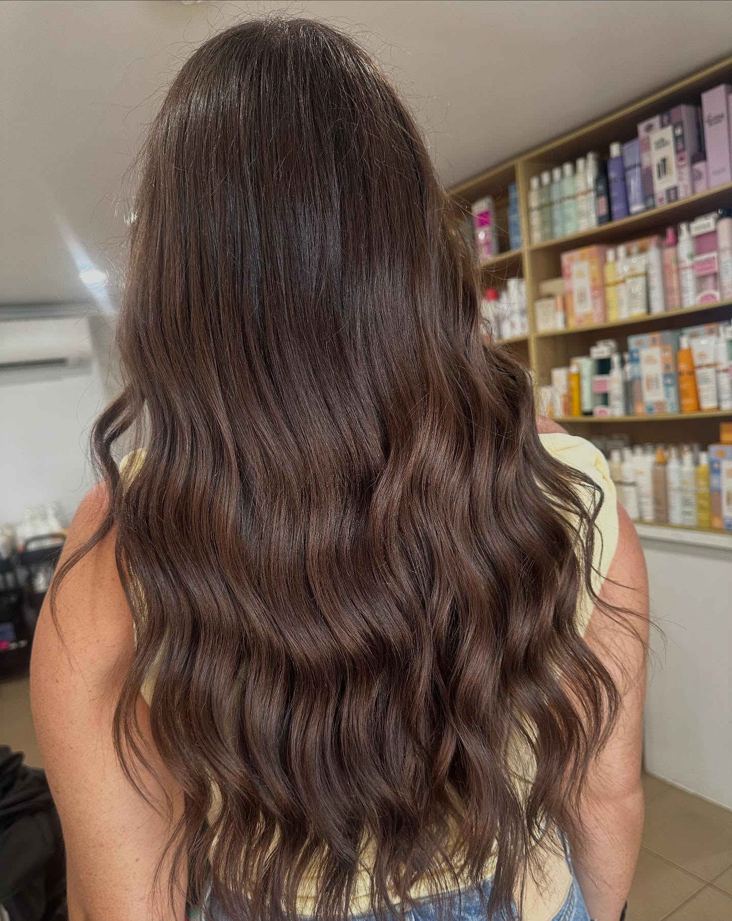Chocolate brown hair colour with natural waves showcasing salon colour results