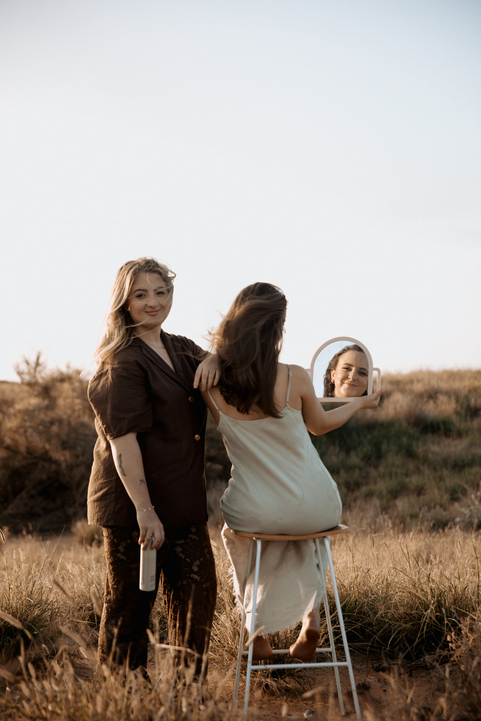 Kate Bonnie hairdresser consulting with client using mirror outdoors in Pilbara South Hedland